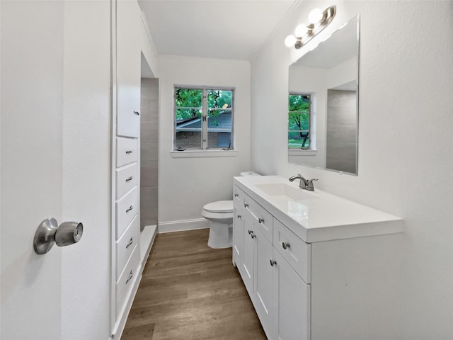 bathroom with crown molding, vanity, toilet, baseboards, and wood finished floors