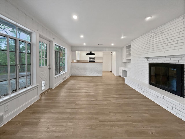 unfurnished living room with recessed lighting, visible vents, wood finished floors, and a fireplace
