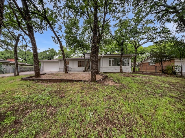 back of property featuring board and batten siding, an attached garage, fence, and driveway