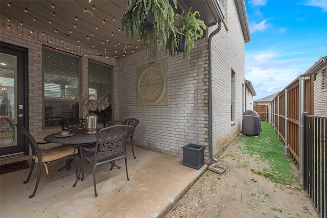 view of patio with a fenced backyard, outdoor dining space, and central AC