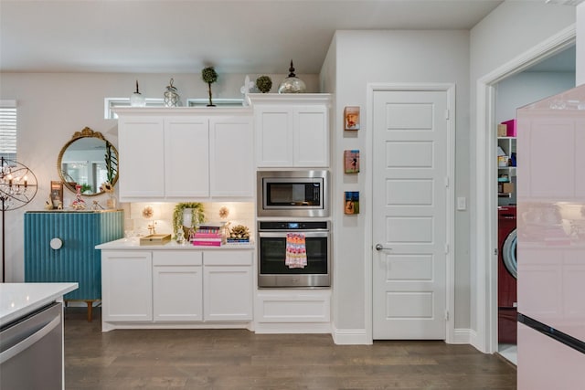 kitchen with decorative backsplash, dark wood-type flooring, light countertops, white cabinetry, and stainless steel appliances