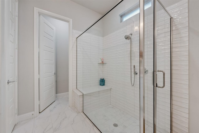 full bath featuring baseboards, marble finish floor, and a stall shower