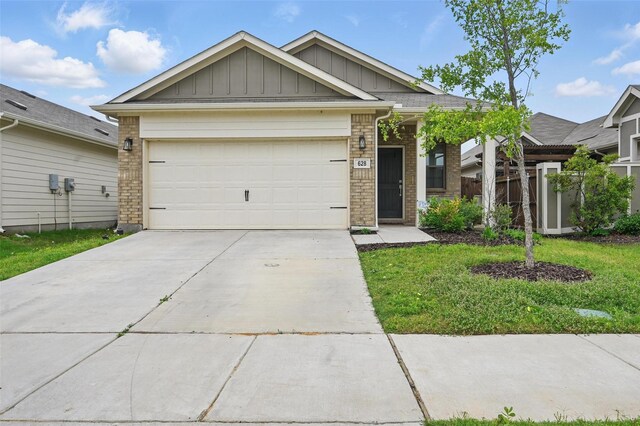 628 Coleman St, Aubrey, TX 76227 - view of front of home featuring board and batten siding, driveway, brick siding, a front lawn, and an attached garage
