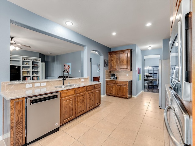 5732 Chateau Dr, Sachse, TX 75048 - kitchen with stainless steel appliances, a sink, tasteful backsplash, arched walkways, and a ceiling fan