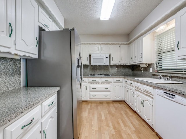 12203 Cross Creek Dr, Dallas, TX 75243 - kitchen featuring a textured ceiling, a sink, white cabinets, light wood finished floors, and white appliances