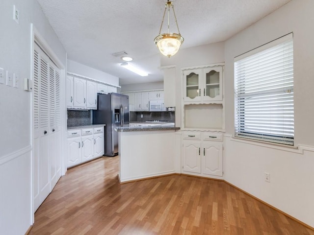 12203 Cross Creek Dr, Dallas, TX 75243 - kitchen with stainless steel fridge with ice dispenser, white cabinets, and a peninsula