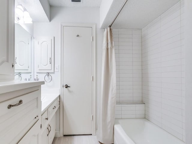 12203 Cross Creek Dr, Dallas, TX 75243 - bathroom featuring vanity, a textured ceiling, and shower / tub combo with curtain
