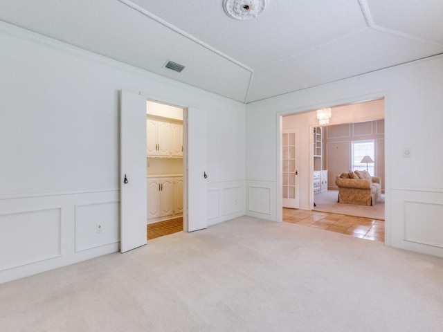 12203 Cross Creek Dr, Dallas, TX 75243 - unfurnished bedroom featuring visible vents, a decorative wall, light carpet, a notable chandelier, and vaulted ceiling