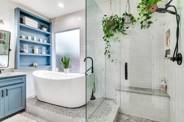bathroom featuring a freestanding tub, vanity, a shower stall, and built in shelves