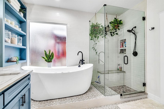 full bath featuring vanity, a soaking tub, tile patterned flooring, and a stall shower