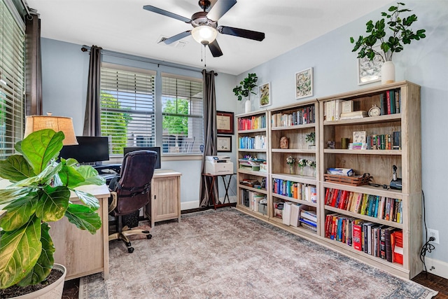 office space with baseboards, ceiling fan, and visible vents
