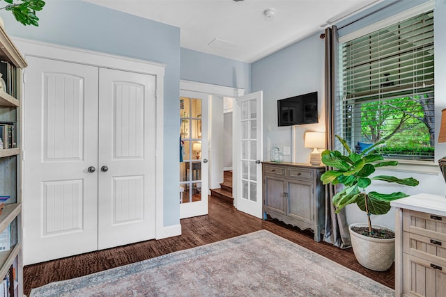 interior space featuring a closet, baseboards, french doors, and wood finished floors