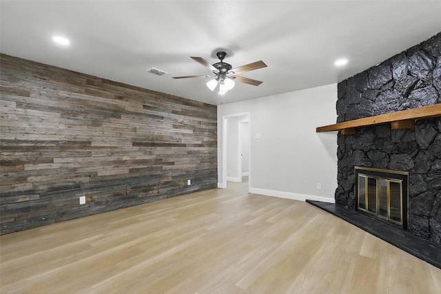 2708 Ash Park Dr, Richland Hills, TX 76118 - unfurnished living room featuring a ceiling fan, wooden walls, a stone fireplace, wood finished floors, and baseboards