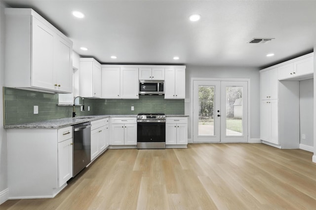 2708 Ash Park Dr, Richland Hills, TX 76118 - kitchen featuring stainless steel appliances, a sink, light wood-style floors, tasteful backsplash, and baseboards