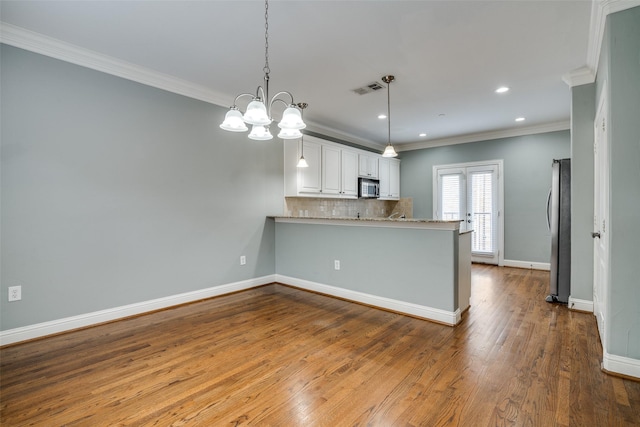 kitchen with visible vents, ornamental molding, decorative backsplash, a chandelier, and stainless steel appliances