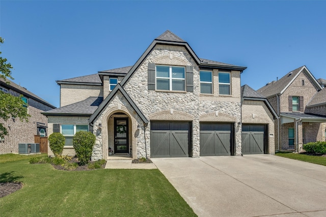 8480 Kincaid Ln, Frisco, TX 75036 - view of front of house with roof with shingles, stone siding, a garage, a front yard, and driveway