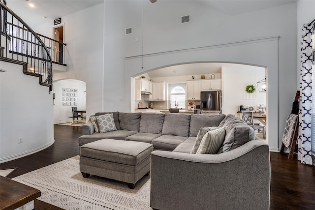 8480 Kincaid Ln, Frisco, TX 75036 - living room featuring visible vents, arched walkways, a towering ceiling, and wood finished floors