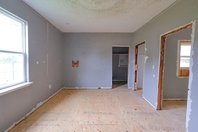 unfurnished room featuring a textured ceiling and a healthy amount of sunlight