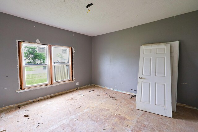 unfurnished room featuring a textured ceiling and a healthy amount of sunlight