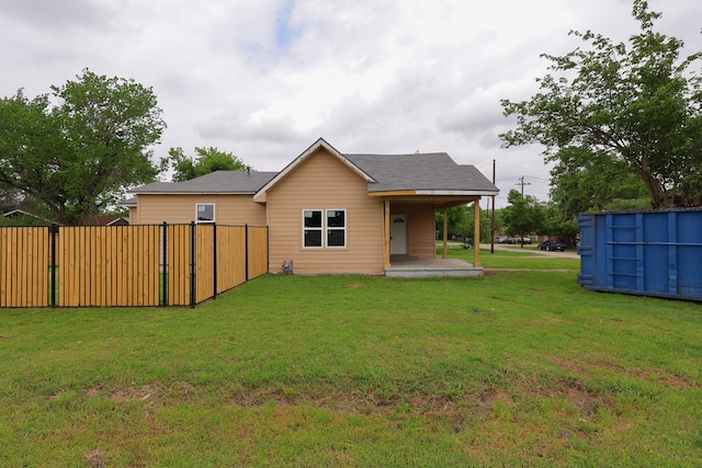 rear view of property with a lawn and fence
