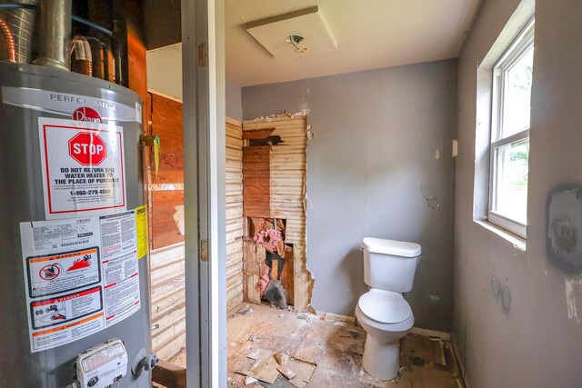 bathroom with water heater, plenty of natural light, and toilet
