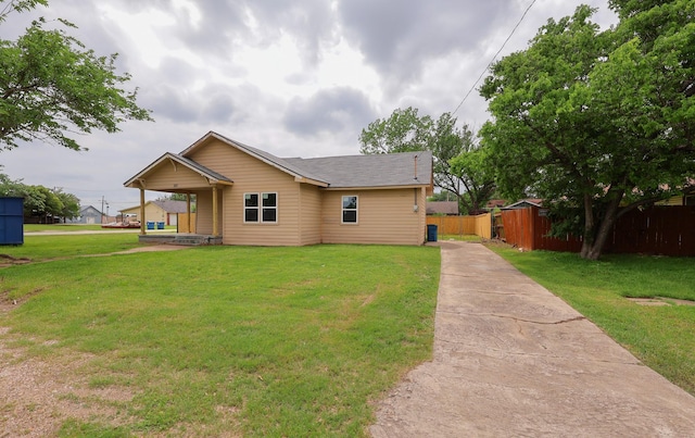 view of front of home with a front lawn, fence, and driveway
