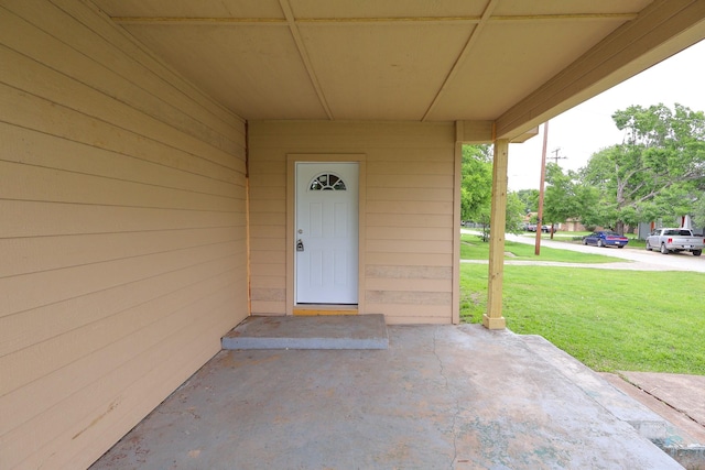 view of exterior entry with a lawn