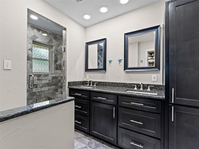 2345 Ravenwood Dr, Grand Prairie, TX 75050 - bathroom with double vanity, a sink, stone finish flooring, and a stall shower