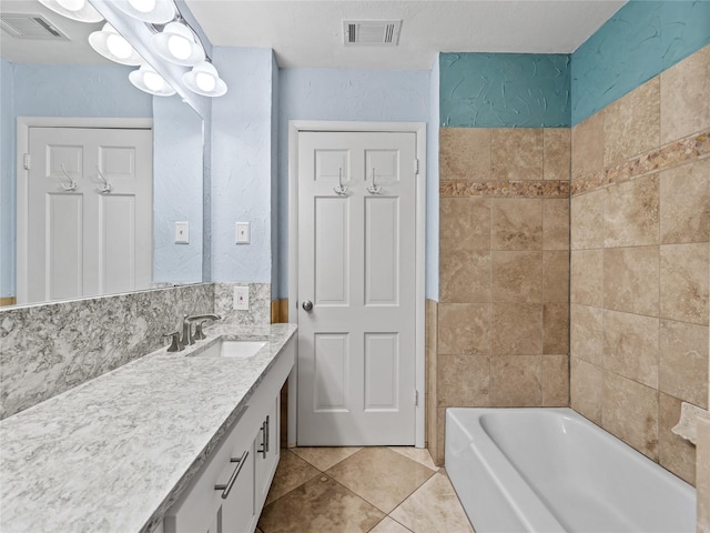 2345 Ravenwood Dr, Grand Prairie, TX 75050 - full bathroom featuring tile patterned floors, visible vents, a bath, and vanity