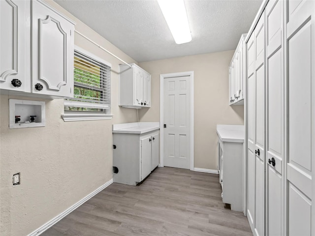 2345 Ravenwood Dr, Grand Prairie, TX 75050 - washroom with cabinet space, a textured ceiling, baseboards, and hookup for a washing machine