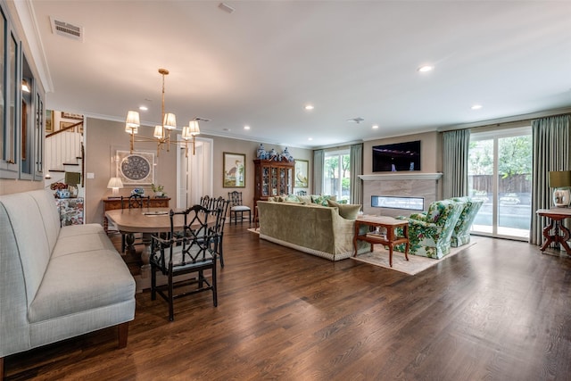 dining area with visible vents, ornamental molding, a healthy amount of sunlight, and an inviting chandelier