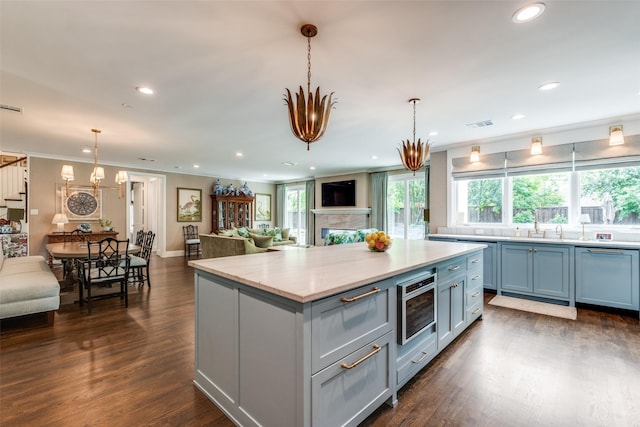 kitchen featuring a kitchen island, open floor plan, a chandelier, recessed lighting, and dark wood-type flooring