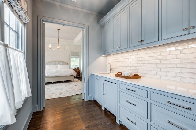 interior space featuring crown molding, light countertops, backsplash, and a sink