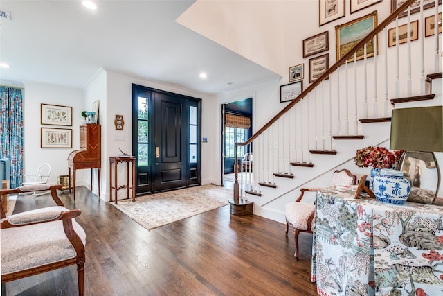 foyer featuring crown molding, recessed lighting, stairs, and wood finished floors