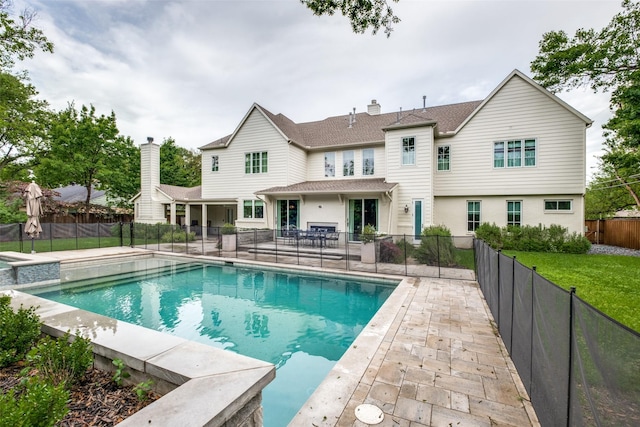 view of swimming pool with a fenced backyard, a patio, and a pool with connected hot tub
