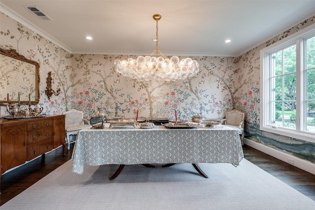 dining room featuring visible vents, dark wood finished floors, crown molding, and a notable chandelier