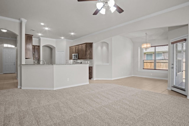 2217 Caroline Dr, Weatherford, TX 76087 - unfurnished living room featuring arched walkways, light carpet, light tile patterned floors, and ceiling fan with notable chandelier