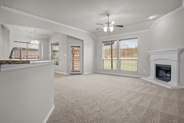 2217 Caroline Dr, Weatherford, TX 76087 - unfurnished living room featuring light colored carpet, a fireplace with raised hearth, ceiling fan with notable chandelier, a healthy amount of sunlight, and ornamental molding