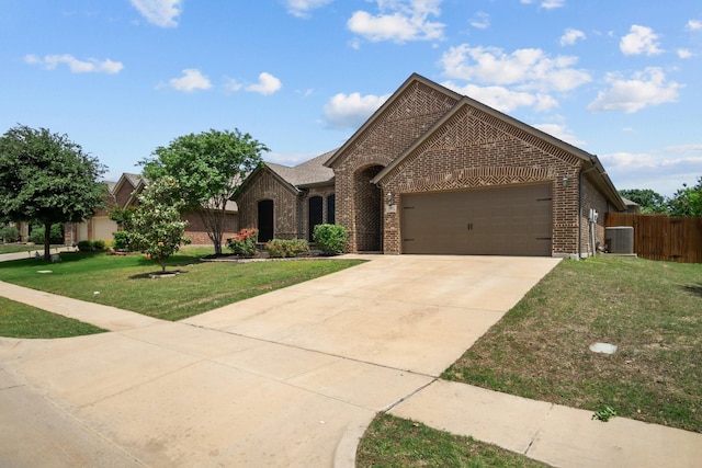 2217 Caroline Dr, Weatherford, TX 76087 - view of front of home featuring central AC, fence, a front yard, brick siding, and an attached garage