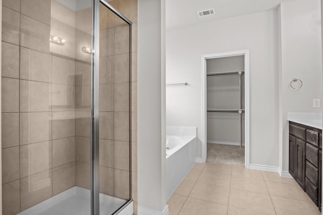 2217 Caroline Dr, Weatherford, TX 76087 - bathroom featuring vanity, a spacious closet, visible vents, a bath, and a stall shower