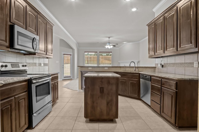 2217 Caroline Dr, Weatherford, TX 76087 - kitchen with crown molding, appliances with stainless steel finishes, a sink, a ceiling fan, and a peninsula