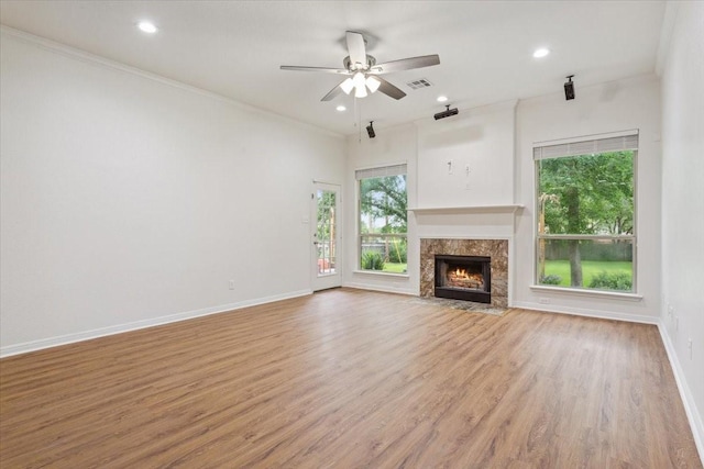 unfurnished living room with crown molding, ceiling fan, light wood-style floors, baseboards, and visible vents
