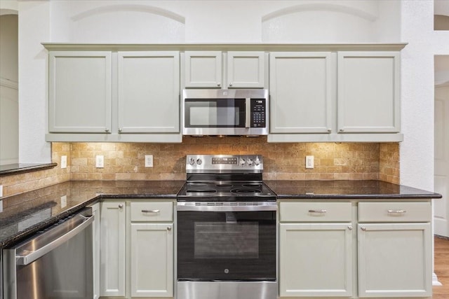 kitchen featuring dark stone counters, decorative backsplash, and appliances with stainless steel finishes