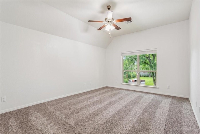 carpeted empty room with a ceiling fan, baseboards, visible vents, and lofted ceiling