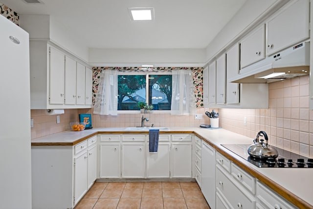 kitchen featuring tasteful backsplash, white cabinetry, light countertops, under cabinet range hood, and light tile patterned flooring