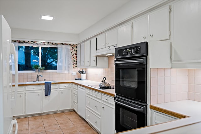 kitchen with black appliances, backsplash, under cabinet range hood, and white cabinetry