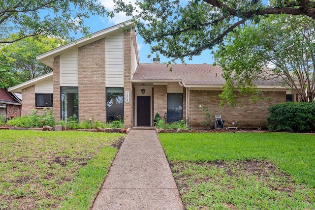 view of front of home featuring brick siding and a front yard