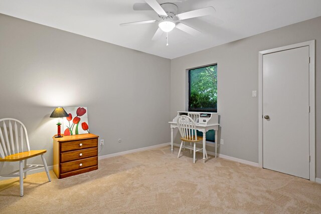 carpeted office featuring baseboards and ceiling fan