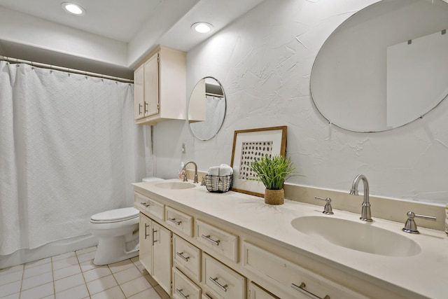 bathroom featuring double vanity, toilet, a sink, and tile patterned flooring