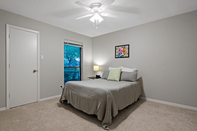 bedroom featuring baseboards, light colored carpet, and ceiling fan
